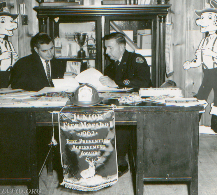 1962 - John Drury and Clinton Duke discussing upcoming fire prevention program from Hartford Insurance