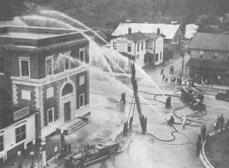 1930 - &quot;A demonstration showing all of the equipment and the pumper throwing 864 gallons per minute. Five streams of water are clearly shown playing on the bank building.&quot;